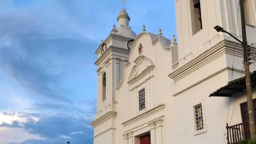 Side view of the cathedral's facade, highlighting the side towers with their bell towers and a beautiful blue sky.