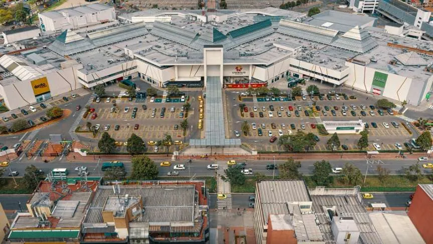 Plano general de la fachada de una gran zona de edificaciones de mediana altura, con una amplia área de parqueaderos.