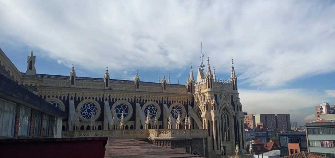 Panorámica de lado de la parte alta de la iglesia de Chiquinquirá. Destacan las puntas de las torres de estilo gótico cerca del cielo azul. 