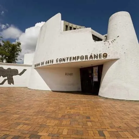 Fachada del Museo de Arte Contemporáneo, edificio blanco de diseño moderno con entrada sobre plaza de ladrillo.