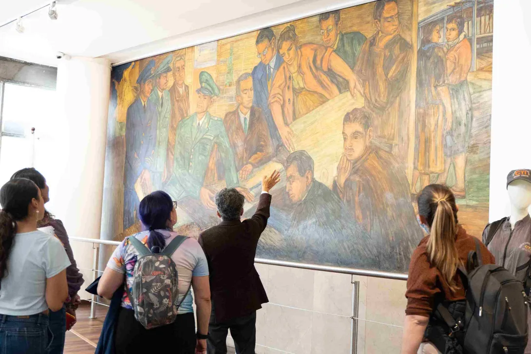 Visitors view a large mural during a guided tour of a museum in Bogotá.