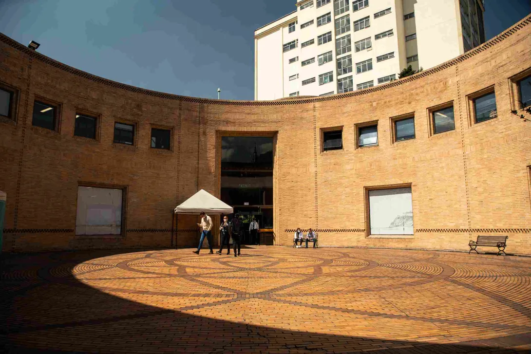 Patio interior del Archivo General de la Nación, con arquitectura en ladrillo, diseño circular y visitantes recorriendo el espacio.