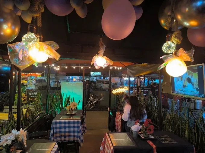 Foto1: Interior de Gaia Bogotá, con mesas decoradas, iluminación ambiental, elementos festivos y pantallas que crean una atmósfera moderna y animada.