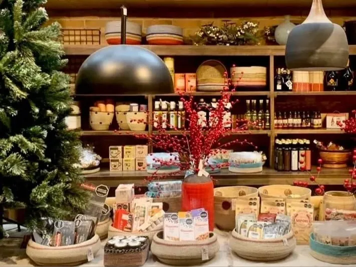  Interior de una tienda de productos de cacao y chocolate, con estanterías decoradas y productos artesanales.