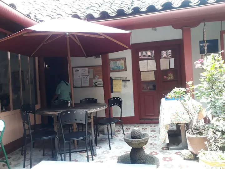 Patio interior de restaurante tradicional, con mesas al aire libre y decoración colorida.