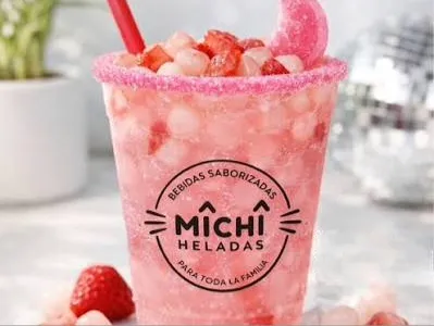 Bebida saborizada de fresa con hielo, fruta fresca y escarchado de color rosa.