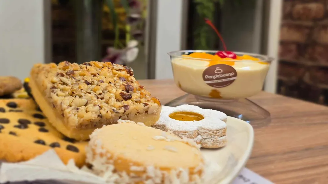Selección de galletas artesanales y un postre helado con cereza servidos sobre una mesa en la repostería Tres Postres.