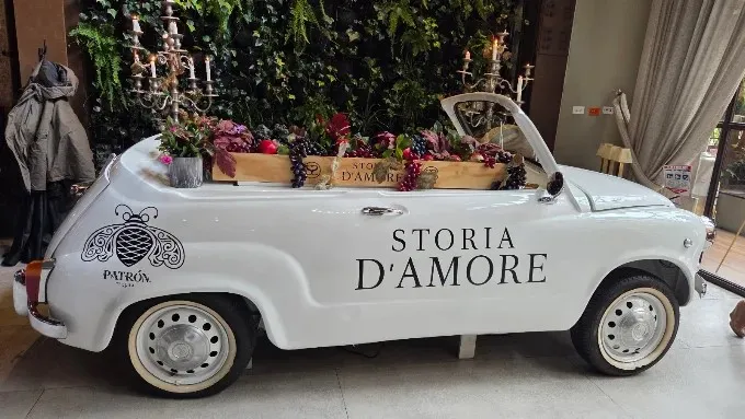 Automóvil clásico blanco decorado con frutas y flores en el interior de Storia D’Amore.