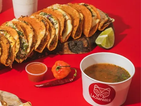 Tacos de birria acompañados de consomé, limón y salsas de la casa.