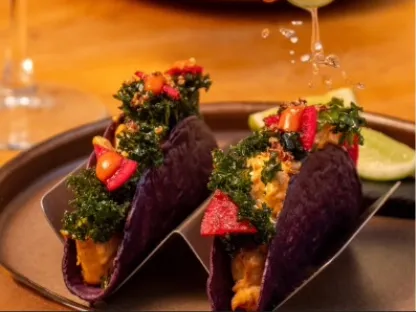 Tacos de tortilla morada rellenos y acompañados de vegetales frescos, servidos en un plato de presentación.