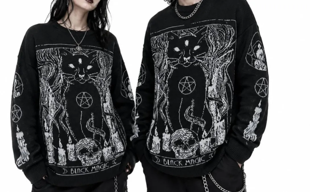 Dos personas lucen buzos negros de estilo alternativo con ilustraciones góticas de gatos, pentagramas, calaveras y castillos, acompañados de accesorios metálicos que refuerzan una estética oscura y mística.