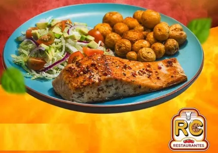 Filete de salmón acompañado de ensalada fresca y papas doradas.