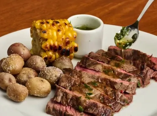 Corte de res a la parrilla, acompañado de papas, mazorca asada y salsa de la casa.